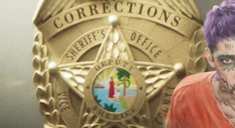 Золотой значок департамента шерифа с надписью Corrections на фоне, справа человек с фиолетовыми волосами, татуировками на лице и в оранжевой тюремной робе, видна только часть лица и плечо.